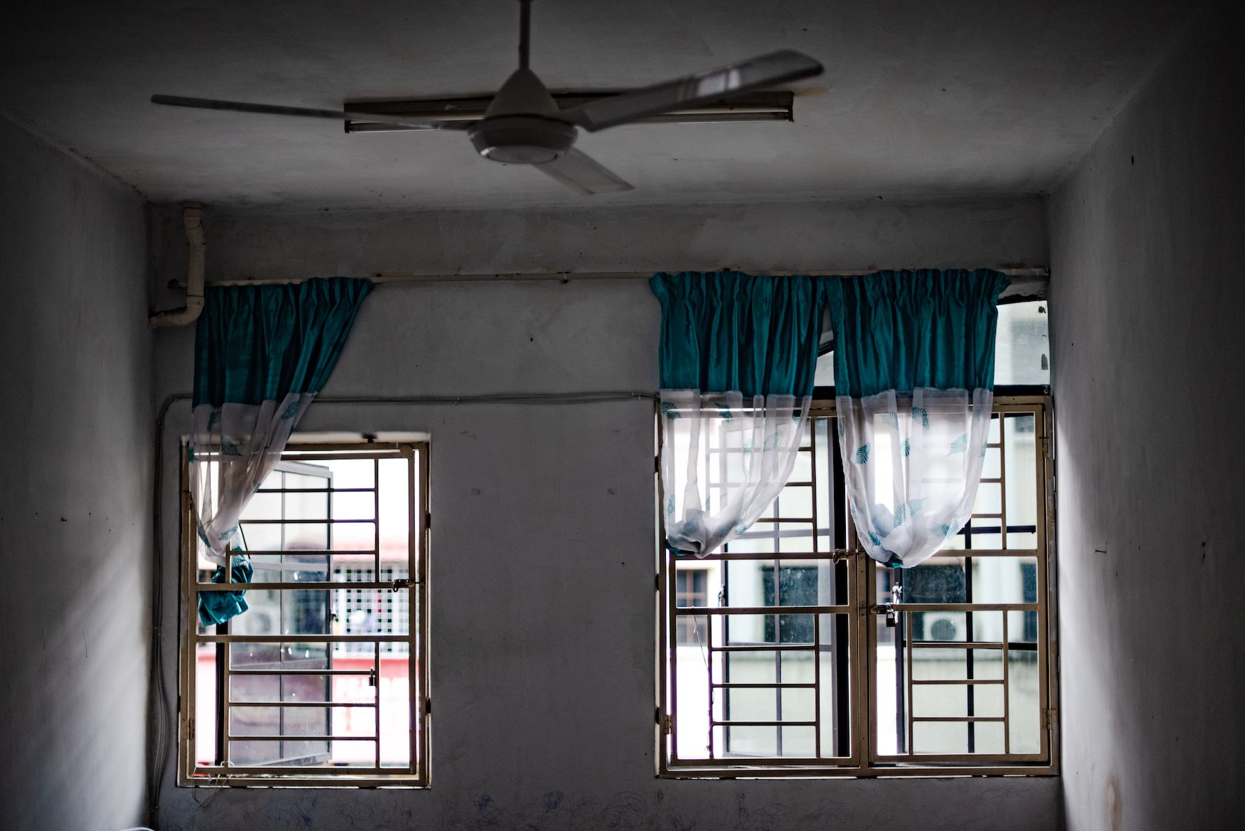 A pair of windows in a small living room in a block of flats in Kuala Lumpur Malaysia, where Hicheal, a refugee from Myanmar lives 