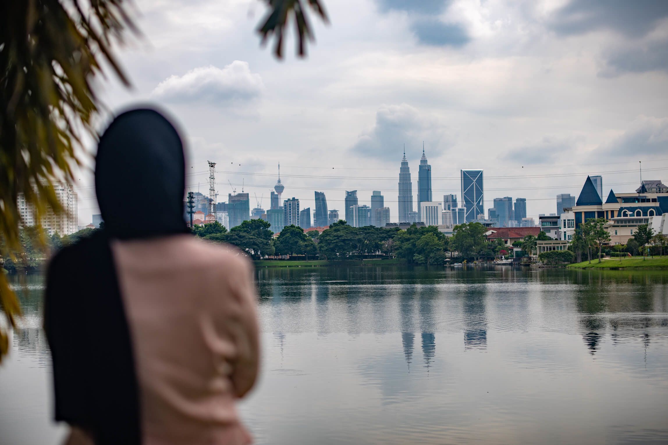 A woman seen from the back gazes at the Petronas twin towers in Kuala Lumpur. 