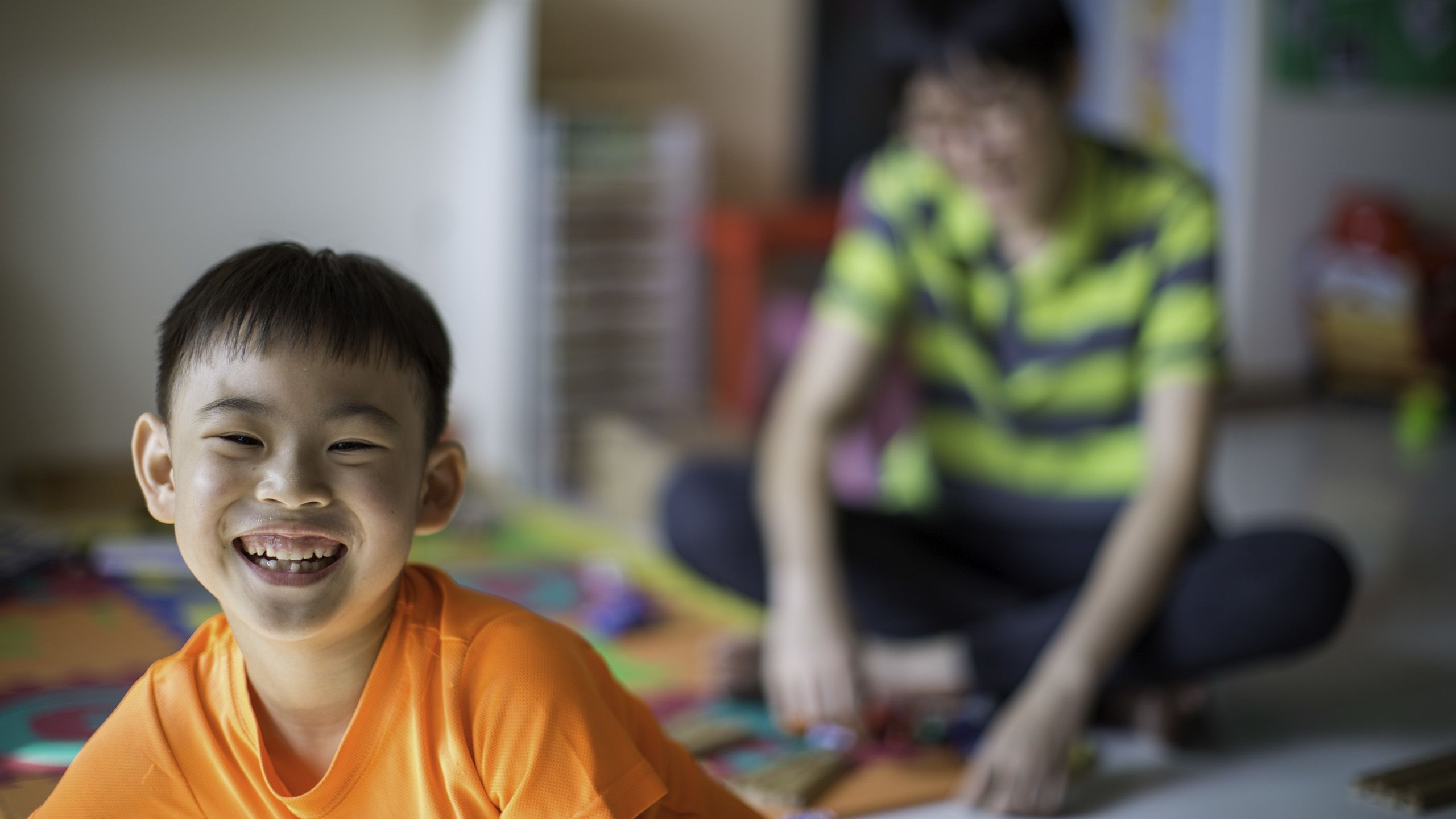 Jeston, a child with autism smiles at the camera.